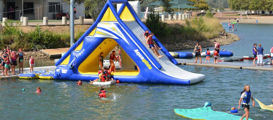 kids and adults playing on an inflatable structure in the water