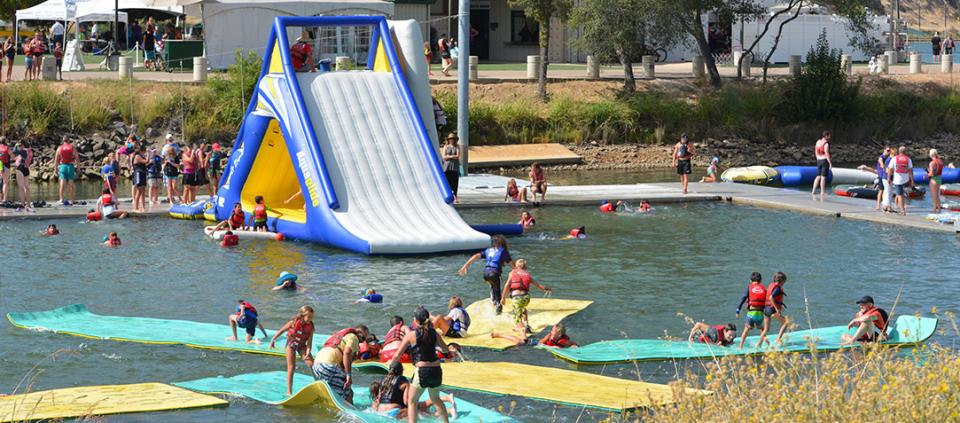 people playing on an inflatable structure on the water
