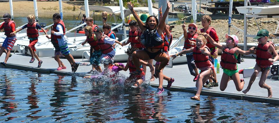 kids jumping into the water off dock