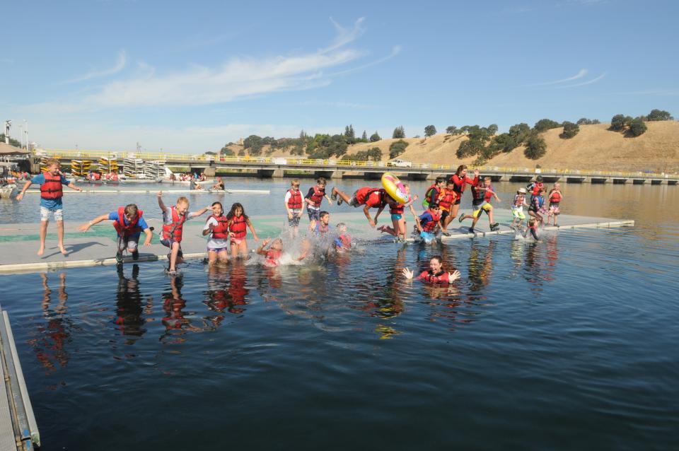 Camp counselor and kids on splash mat