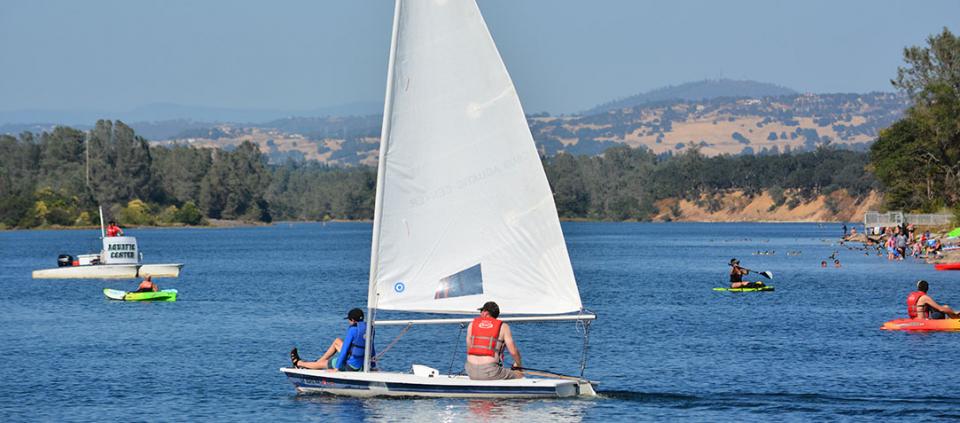 sailboat and kayakers on the water