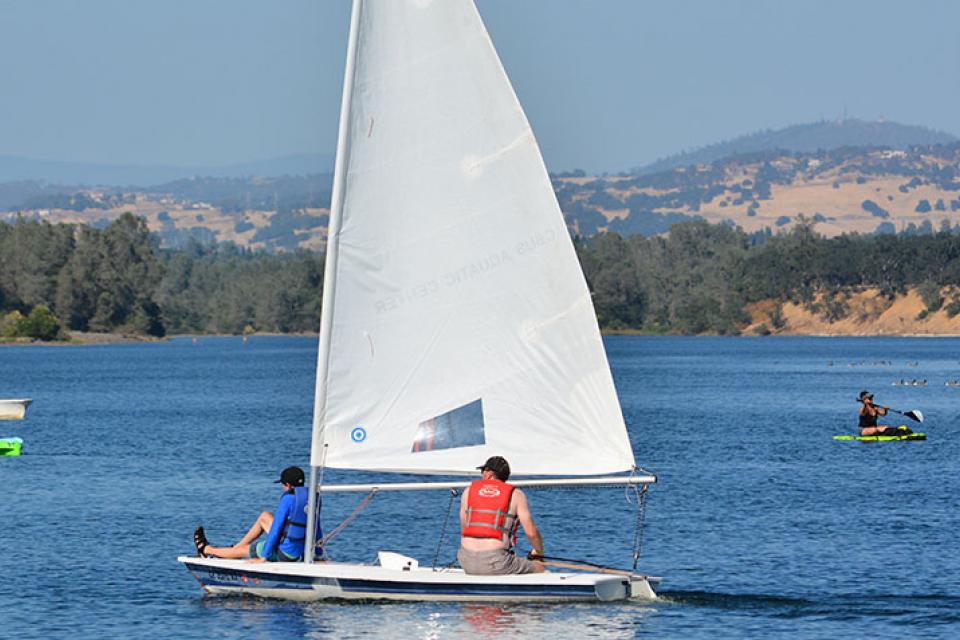 sailboat and kayakers on the water
