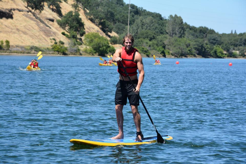 Man stand up paddling on lake natoma